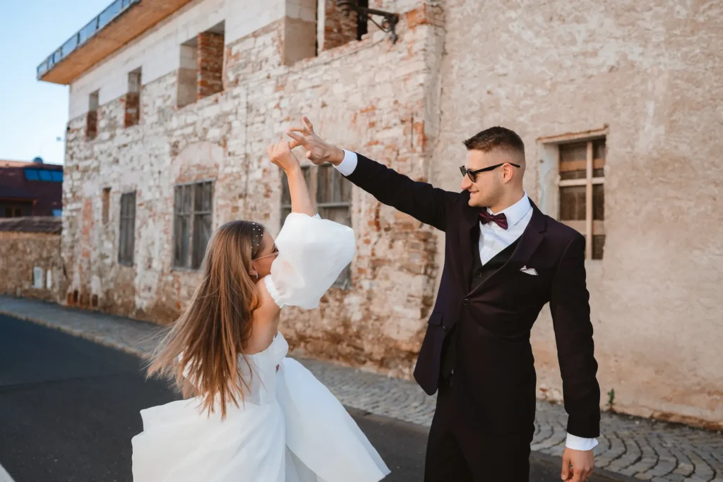 Ženích vytáča nevestu pri tanci na ulici, zachytenie emócie a pohybu ako súčasť ceny svadobného fotografa na Slovensku.